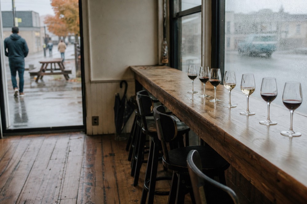 A tasting room bar with several glasses of red and white wine lined up
