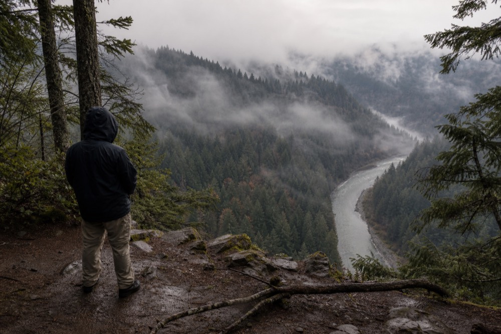 A misty forested ridge above a river valley in the Pacific Northwest
