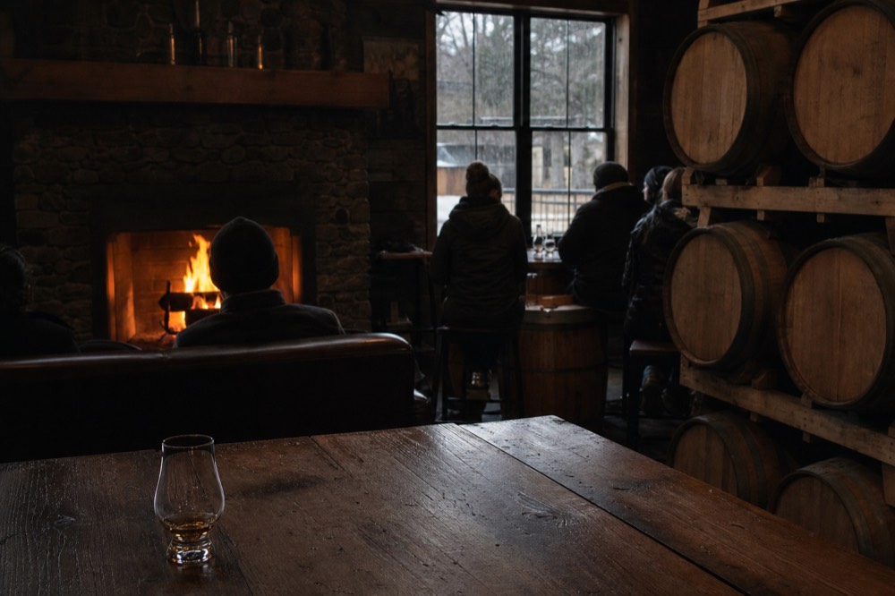 A cozy Willamette Valley tasting room with a fireplace and empty barrel-lined interior