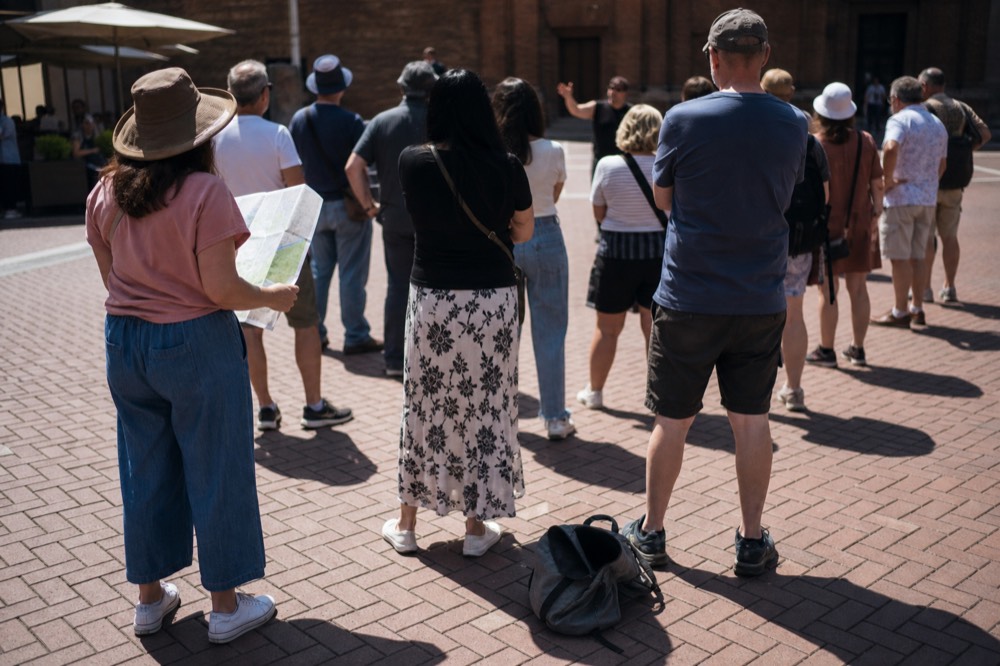 Group of people on a city walking tour listening to a guide