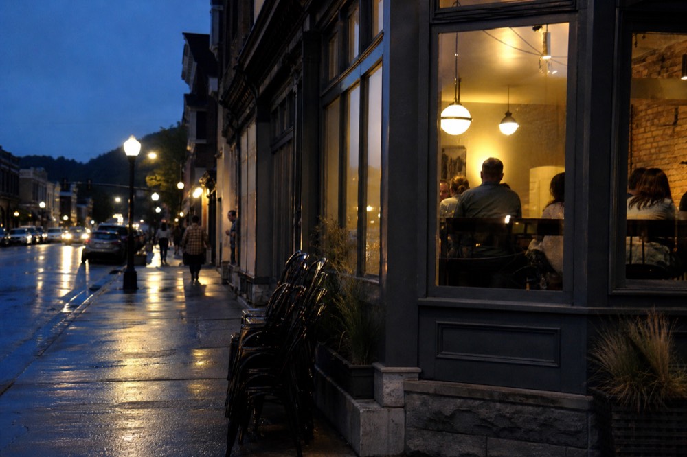 Evening light over a small-town main street with diners walking