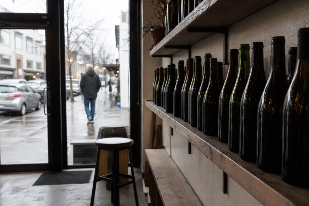 A row of wine bottles for sale on shelves in a small Willamette Valley tasting room